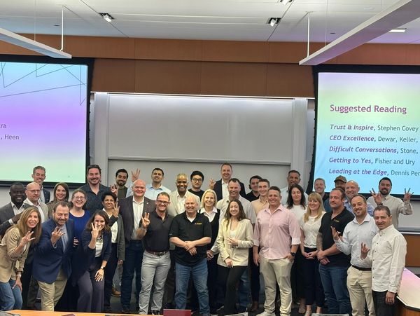 Group photo in a classroom with people smiling and posing.