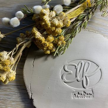 Logo clay stamp of elf atelier with yellow flowers