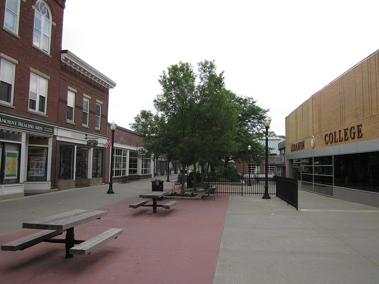 Outdoor seating area with picnic tables between buildings near Lebanon College.