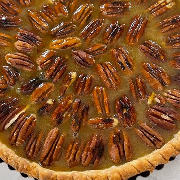 A freshly baked pecan pie with a golden crust and glossy pecans.