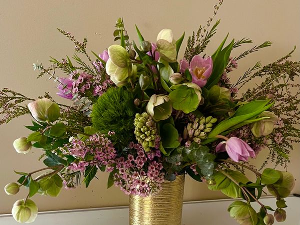 Elegant mixed flower bouquet in a gold vase.