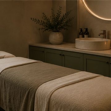 Calming spa room with massage table and soft lighting.