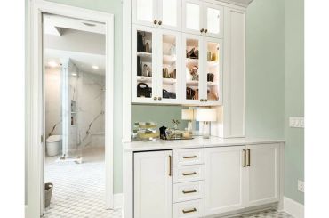 Modern white bathroom cabinet with glass doors and countertop.