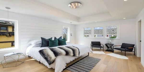 Bright modern bedroom with large bed and seating area.