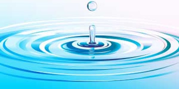 A water droplet creating ripples on a blue surface.