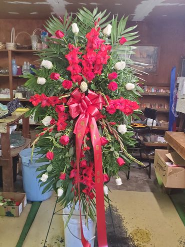 Floral Spray created on an easel. Includes red and white ses and red gladiolas includes bow and ribb
