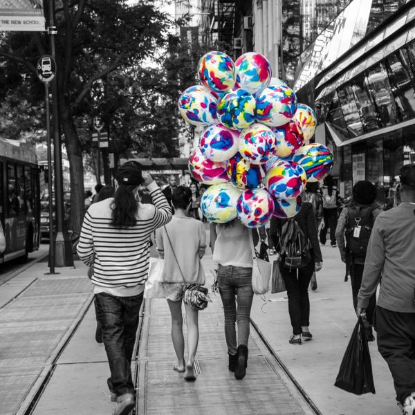 Globos coloridos en una ciudad en blanco y negro.