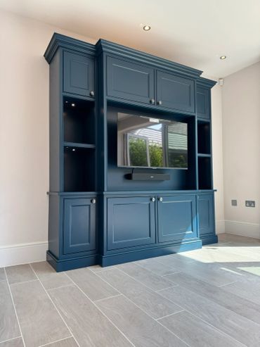 Elegant blue built-in entertainment center with TV and soundbar.