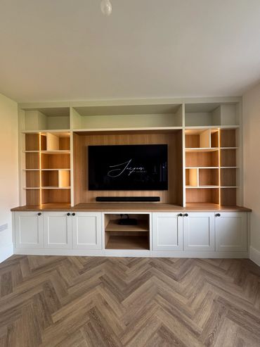 Modern built-in entertainment unit with TV and LED-lit shelves.