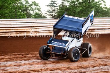 A blue and white sprint car racing on a dirt track.