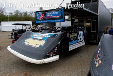 Black and blue dirt late model race car #40 at a racing event.