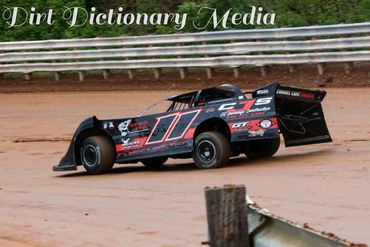 Black and red dirt track race car number 11 on a dirt oval.