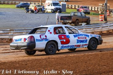 Race car number 9 on a dirt track during a race.