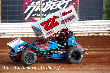 Blue and red sprint car racing on a dirt track with number 22X.
