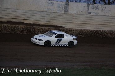 White race car number 1 on a dirt track preparing to turn.