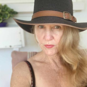 Woman wearing a black hat with a brown band.
