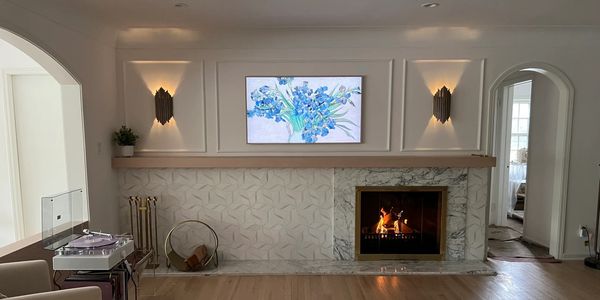 Modernized fireplace wall in Shaker Heights residence featuring custom millwork, marble surround, and integrated lighting in a mid-century home redesign.