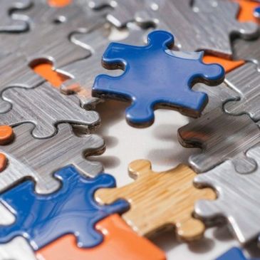 Close-up of puzzle pieces, one blue piece ready to be placed.