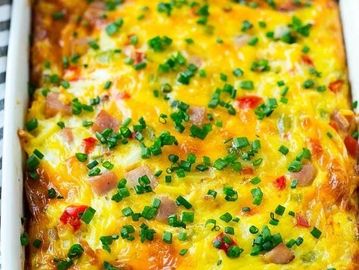 Baked cheesy egg casserole topped with chopped chives.