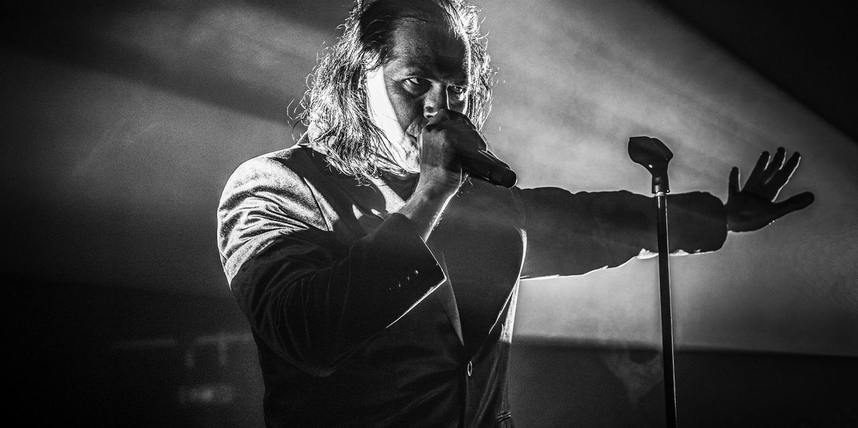 Jeremy Harry Harris singing into a microphone on stage. Picture is black and white