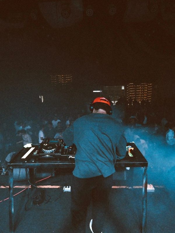 DJ actuando en un club nocturno con público.