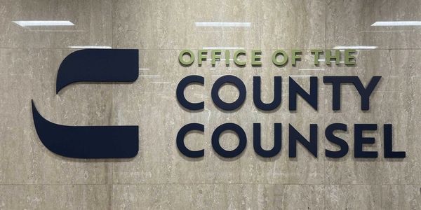 Sign for the Office of the County Counsel on a marble wall.