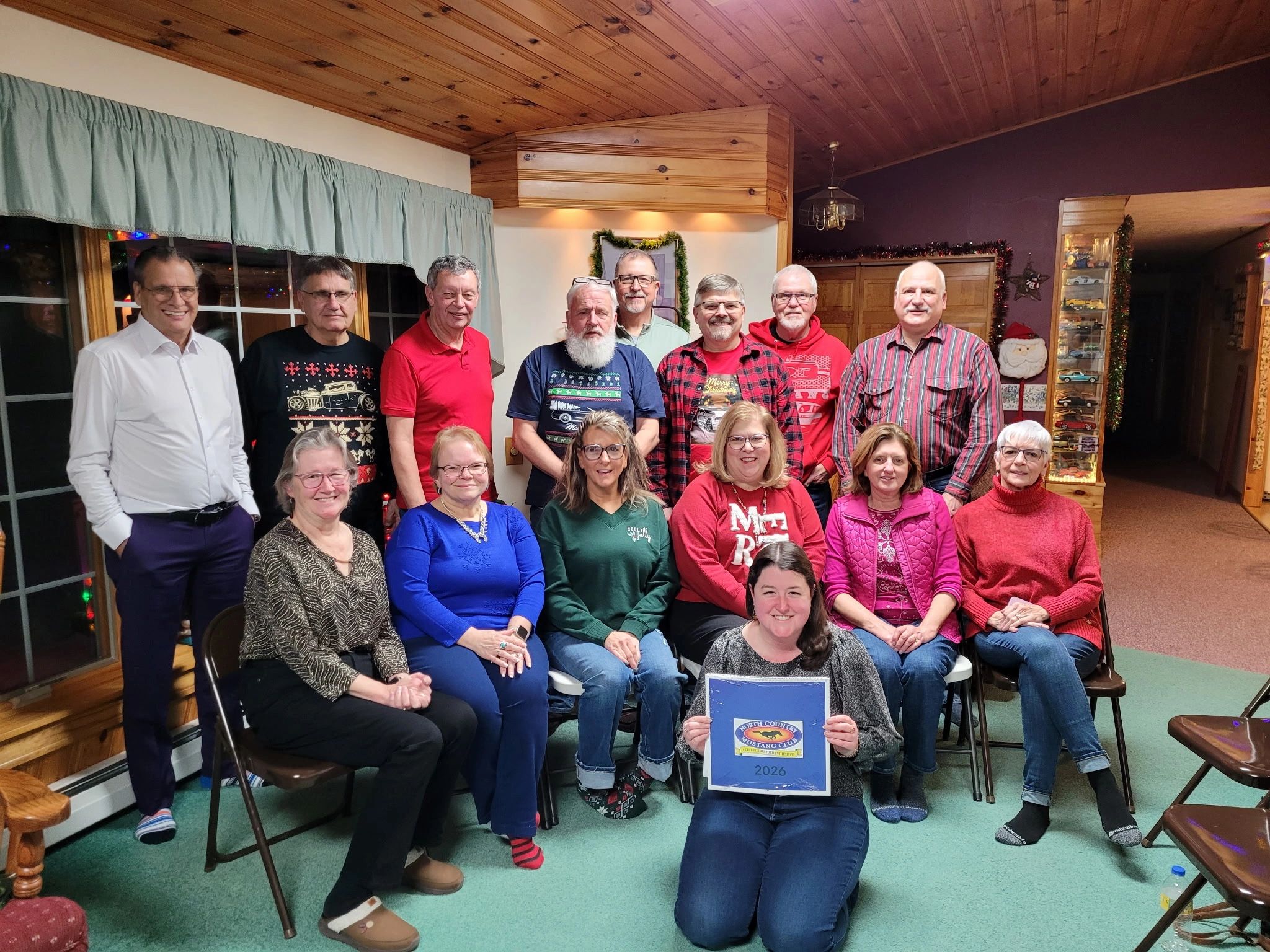 Group photo of 17 adults indoors, smiling and dressed casually.
