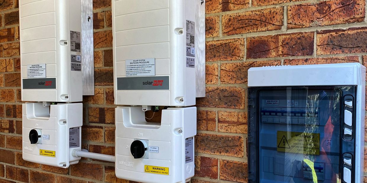 Twin Solaredge Three Phase Inverters on brick wall