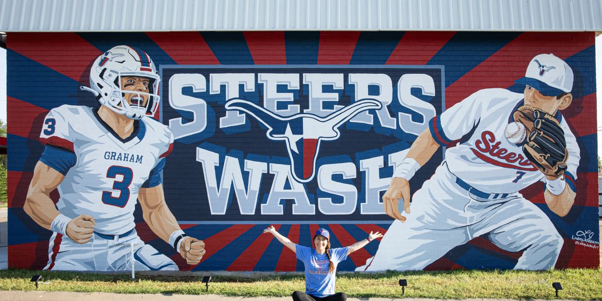 A mural showcasing Graham Steers football and baseball players with a fan sitting in front.