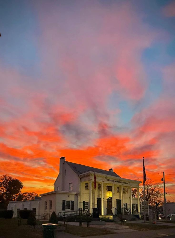 Veterans Memorial Building lit against a vibrant sunset sky.