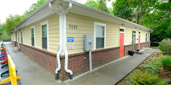 Exterior of a beige office building with red doors.