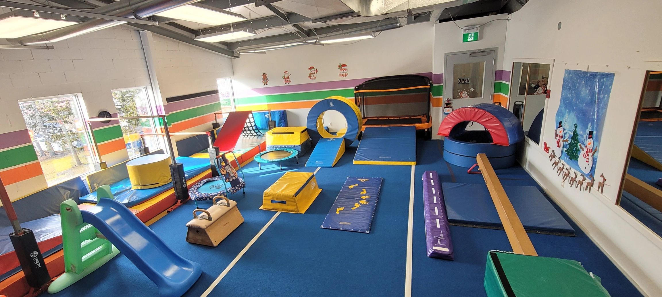 Indoor kids' gym with colorful play equipment.
