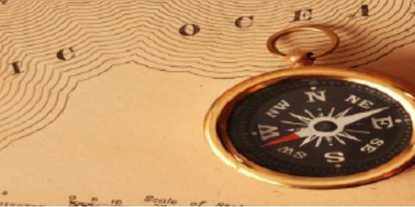An antique compass on a vintage map.