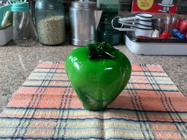 Green bell pepper on a kitchen towel.