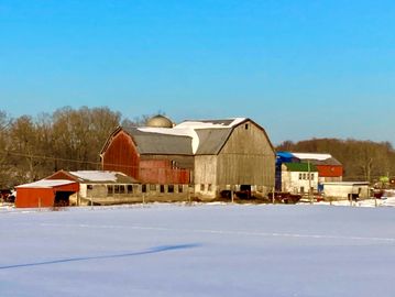 Big red barn and a field covered in snow.