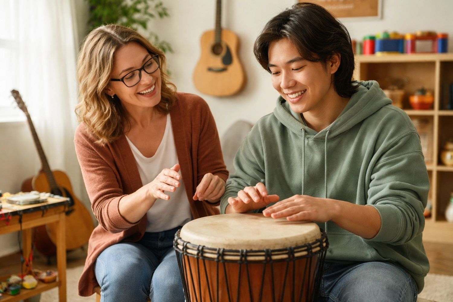 Female music therapist and young adult male client playing a djembe with guitars in the background