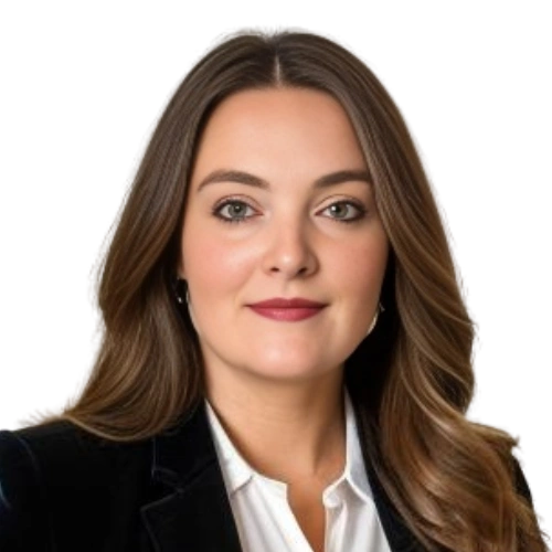 Professional headshot of a confident woman with long brown hair.