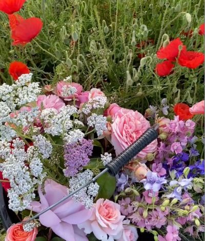 A bouquet of colorful flowers with a black-handled knife stabbed in it.