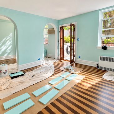 Room being painted with turquoise walls and striped floor.