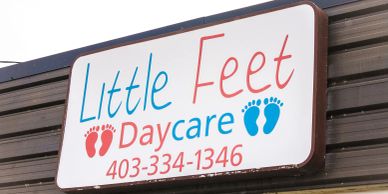 Sign for Little Feet Daycare with contact number.