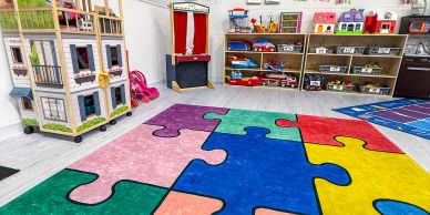 Colorful puzzle-piece carpet in a bright playroom.