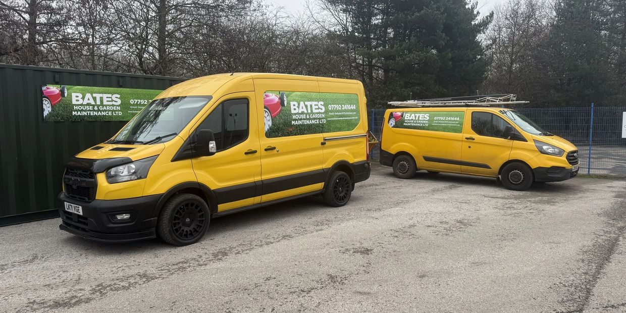 Two yellow Bates House & Garden Maintenance vans parked outdoors.