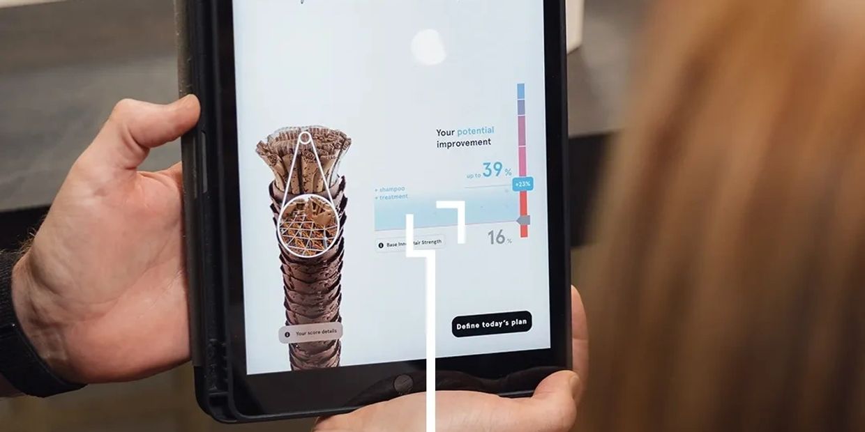 A tablet displaying a hair analysis result screen with the words YOUR INNER HAIR STRENGTH