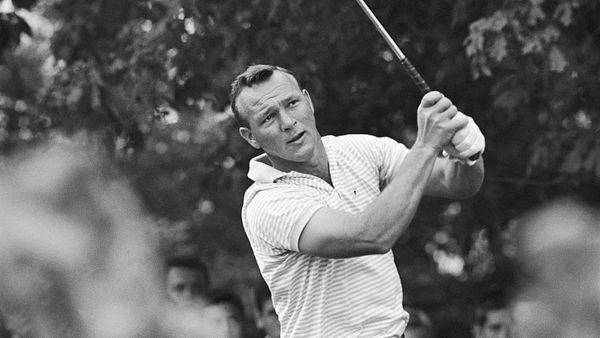 Black and white photo of a golfer mid-swing with intense focus.
