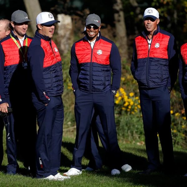 Golfers in red and blue team jackets, tournament sold out with waiting list contact info.