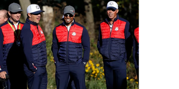 Golf players in team vests smiling.
