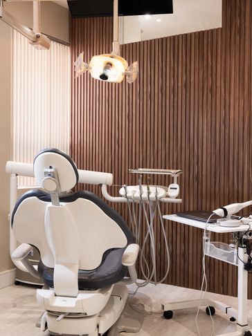 Modern dental clinic room with a dental chair and equipment.