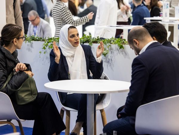 A group of people engaged in a serious discussion around a table.