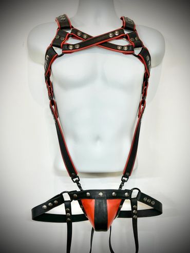 Black and red leather harness with metal studs on a mannequin torso.