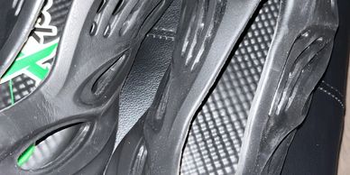 Black futuristic foam slip-on shoes with cut-out designs.